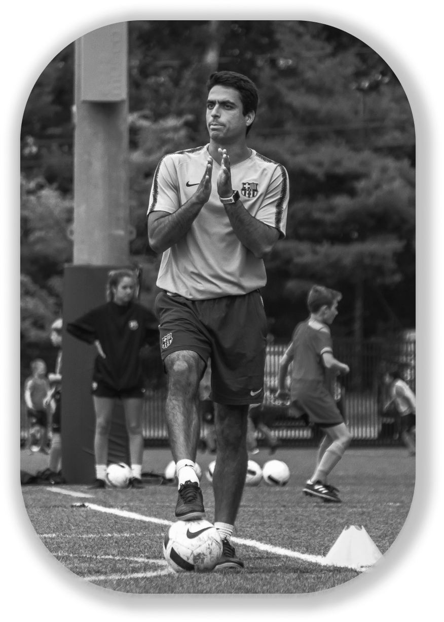 Soccer coach Jorge Reis stepping on a ball